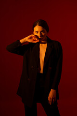Girl in a black jacket on a red background