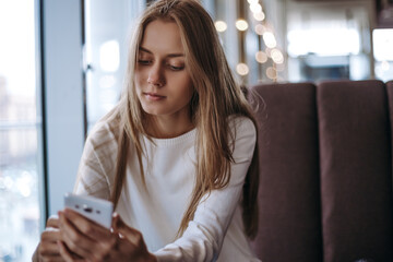 Fototapeta premium unhappy young woman texting message in telephone