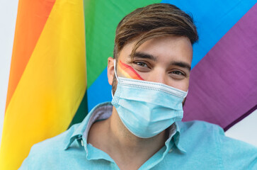 Happy man wearing face protective mask celebrating gay pride event during corona virus pandemic
