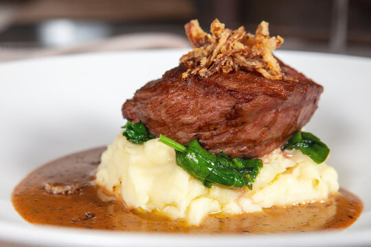 Beef entrecote on mashed potatoes with hot green pepper and red wine sauce