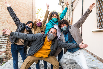 Happy friends walking on city street - New normal concept with young people covered by face masks having fun together 