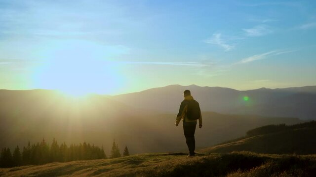 A man travels in the mountains. Beautiful nature of the Carpathian mountains. The concept of travel and active lifestyle. 4K