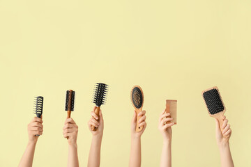 Female hands with hair tools on color background