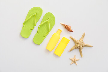 Set of beach accessories with flip-flops on white background