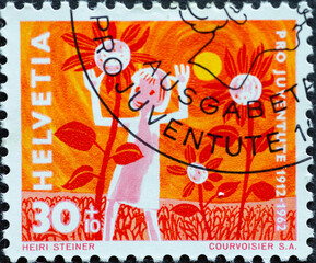 Switzerland - Circa 1962 : a postage stamp printed in the swiss showinga child among flowers