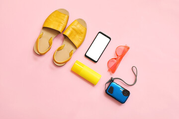 Set of beach accessories with mobile phone on color background
