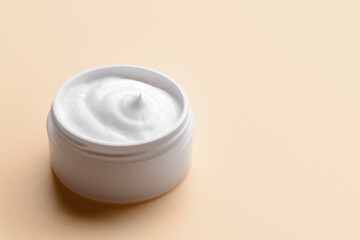 Cosmetic cream jar on color background