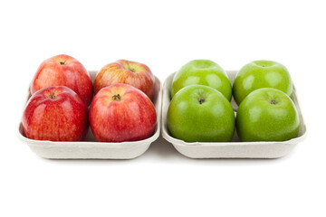 Fresh red and green apples in pulp paper trays next to each other. Studio photo isolated on white.