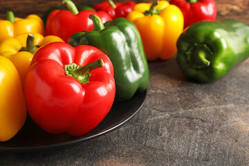 Fresh bell peppers in plate on table