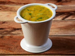 Authentic Indian popular food Dal fry or Traditional Indian soup lentils on rustic wooden background. selective focus