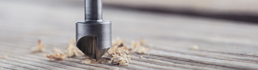 Countersink drill bit make sink in hole for screw in wooden plank - obrazy, fototapety, plakaty