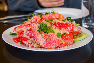 Georgian salad with tomatoes, cucumber, greens and walnut souse
