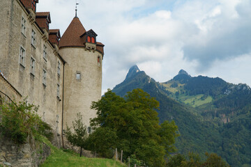Fototapeta na wymiar Tower of the castle with mountains in the background, in the village of of Gruyères, Switerland