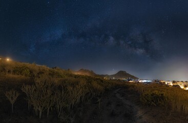 Plakat a mountain and the sea night photography with the milky way and the stars