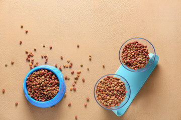 Bowls with dry pet food on color background