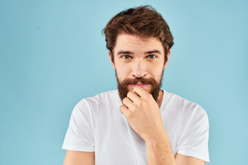 Emotional man with a beard in a white t-shirt blue background fun lifestyle