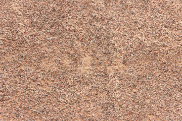 The surface of a rough uneven wall, plastered with fine marble chips.