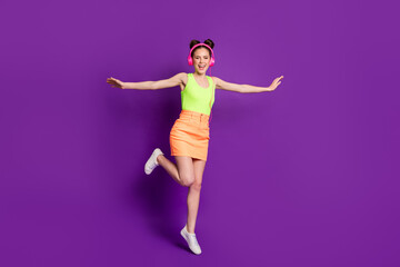 Full length body size view of pretty slim carefree cheerful girl jumping listening stereo enjoying isolated on bright violet color background