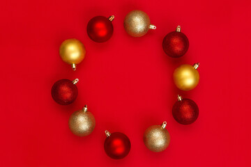 Red and gold Christmas balls decorations on a red background with copy space.Christmas composition. Flat lay, top view. Minimalistic style.