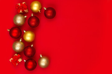 Red and gold Christmas balls decorations on a red background with copy space.Christmas composition. Flat lay, top view. Minimalistic style.