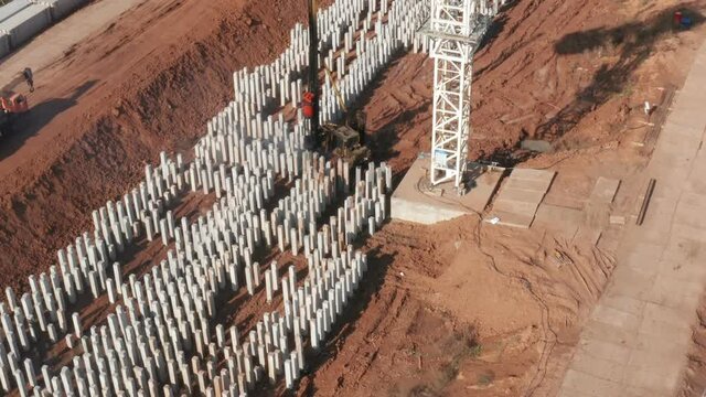Aerial view of pile driving machine with reinforced concrete piles and Crane on construction site. High quality 4k footage