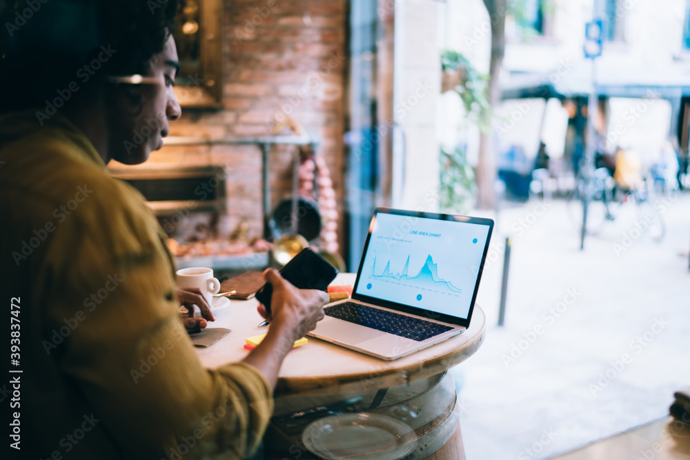 Poster serious millennial hipster guy student browsing graphic charts and information data on laptop comput