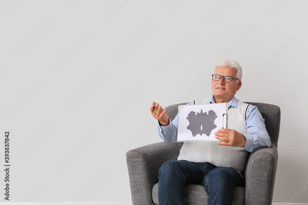 Poster male psychologist sitting in armchair on light background