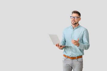 Male psychologist with laptop on light background
