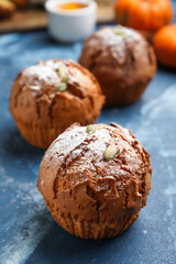 Tasty pumpkin muffins on color background