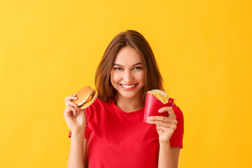 Young woman with french fries and burger on color background