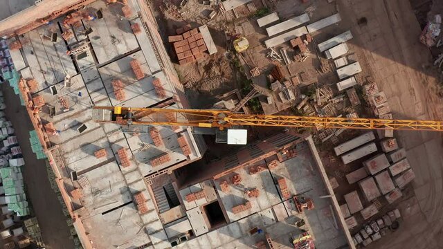 Aerial top Down Shot of a tower crane slewing unit over a construction site. Aerial Flight Over a New Constructions Development. High quality 4k footage