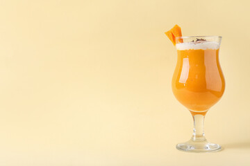 Glass of tasty pumpkin smoothie on color background