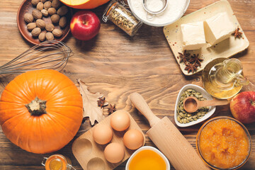 Frame made of ingredients for preparing pumpkin pie on wooden background