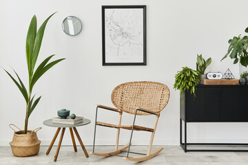 Modern retro concept of home interior with design rattan armchair, coffee table, commode, plants, mock up poster map, decoration and personal accessoreis. Stylish home decor of living room.