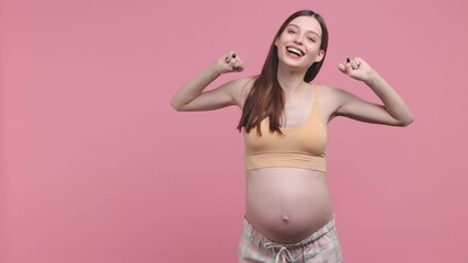 Calm pregnant woman future mom in basic top stroking keeping hands on belly tummy with baby sleep wake up stretching isolated on pink background studio. Maternity family pregnancy gynecology concept
