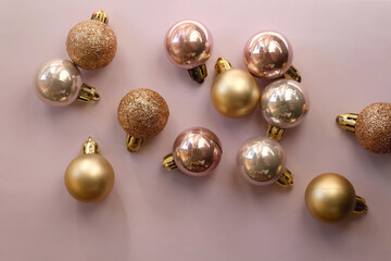 Christmas baubles in gold and pink tones. Top view, pink background.