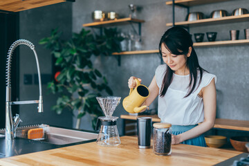キッチンでコーヒーをいれる女性
