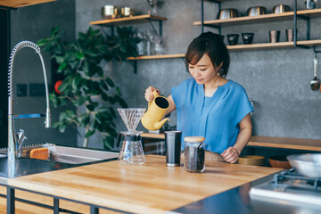 キッチンでコーヒーをいれる女性
