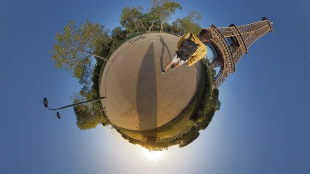Little planet 360 degree sphere. A tourist visiting the Eiffel tower.