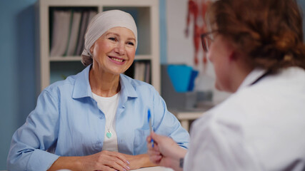 Mature woman with cancer visiting doctor in hospital listening about recovery