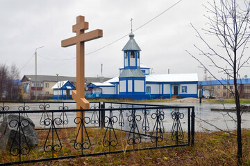 Fototapeta na wymiar Presentation of Mary church (Vvedenskaya church) and memorial cross. Urengoy, Yamalo-Nenets Autonomous Okrug (Yamal), Russia.