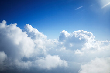 비행기 창문을 통해서 본 하얀 구름이 떠 있는 파란 하늘