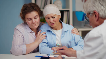 Senior cancer woman with daughter visiting doctor in hospital