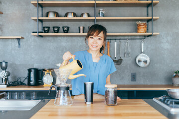 キッチンでコーヒーをいれる女性
