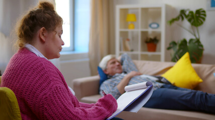 Fototapeta premium Sad gray-haired older man talking about his problems during psychological consultation