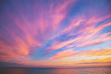 Seascape. Seashore at dramatic blazing sunset. Landscape with sea and bright evening cloudy sky