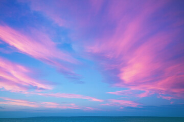 Fototapeta na wymiar Seascape. Seashore at dramatic blazing sunset. Landscape with sea and bright evening cloudy sky