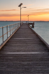 Fototapeta na wymiar The Robe wooden jetty with orange glow at sunset located in South Australi on November 9th 2020