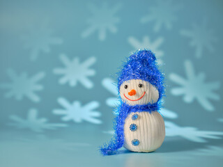 Little snowman on a blue background with snowflakes