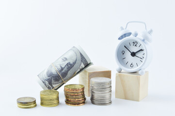 Selective focus of banknote, coins and clock isolated on a white background. Time is money concept.